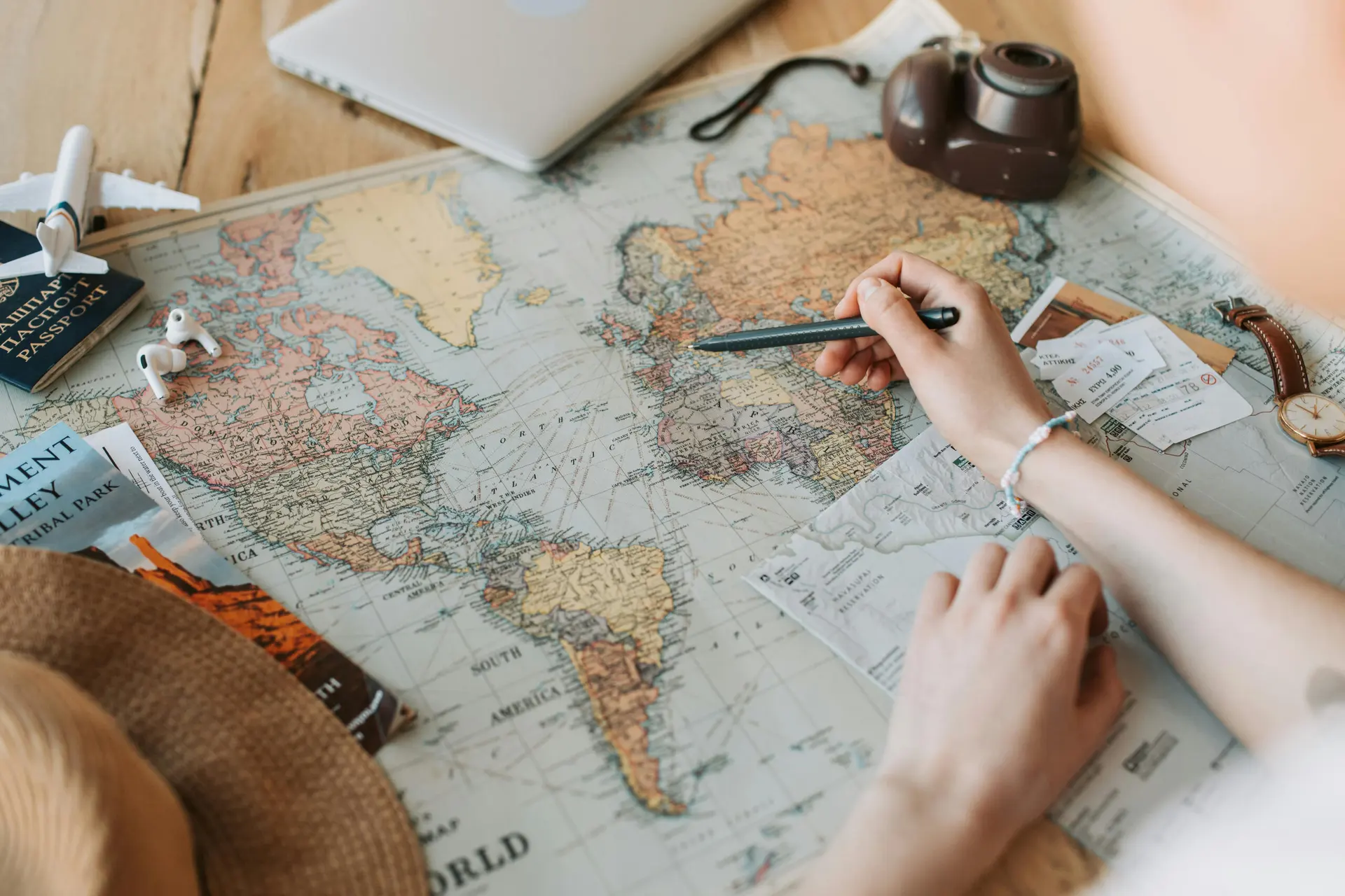 Travel documents, a passport and a notebook arranged on a map while planning a journey.